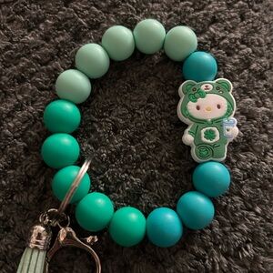 Green hello kitty dressed as care bear wristlet